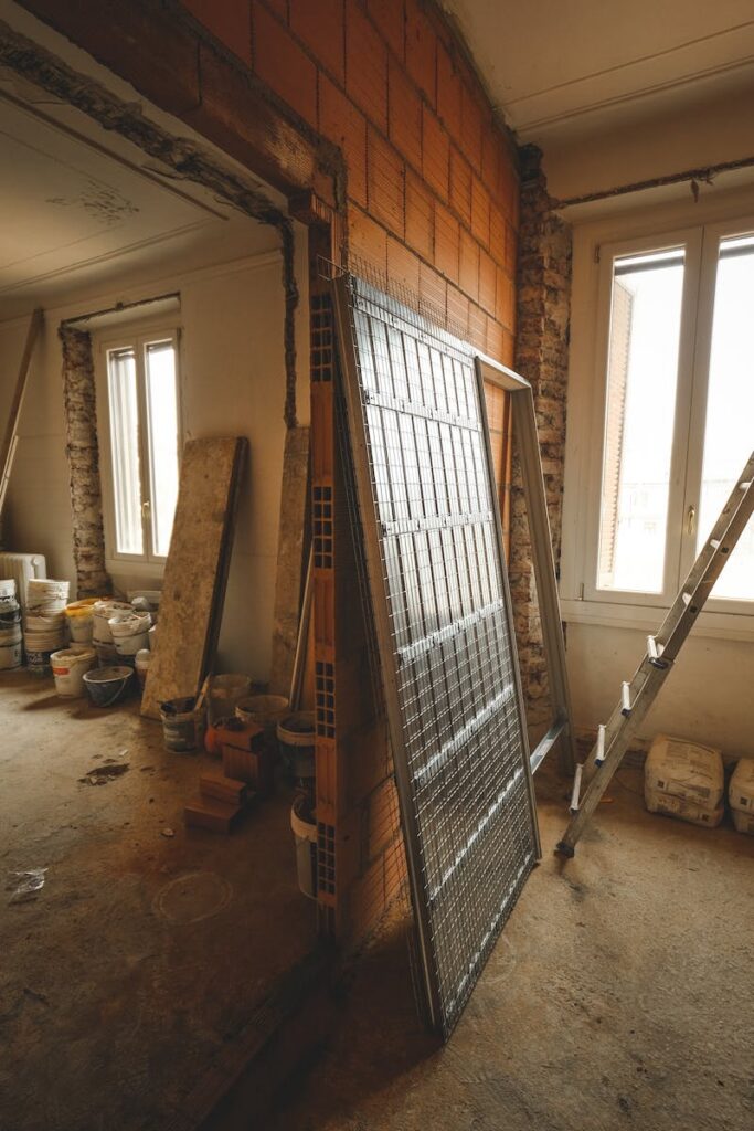 Interior view of a room under renovation with construction materials and a ladder.